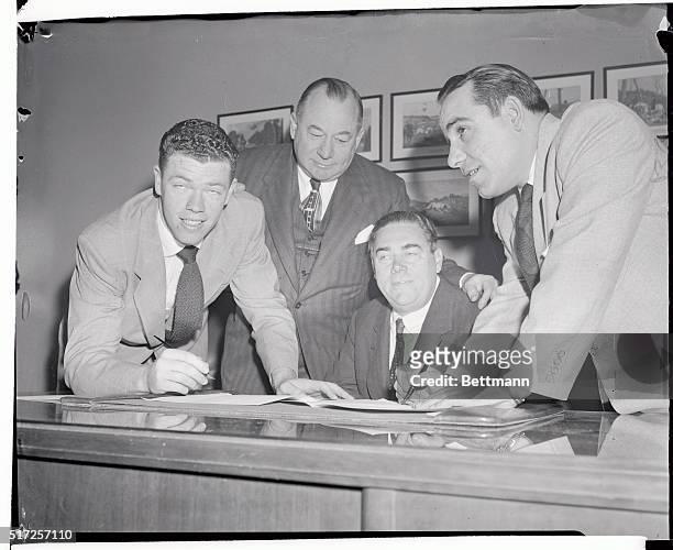 Two VIPs of baseball, Gill McDougald the Rookie of the Year, and Yogi Berra , Most Valuable Player in the American League are shown as they signed...