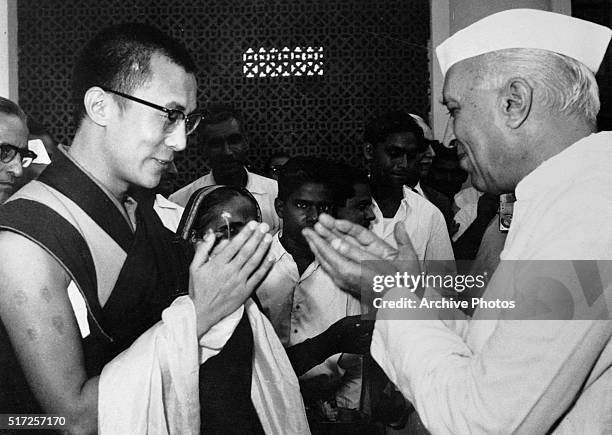 Indian Prime Minister Jawaharlal Nehru exchanges greetings with Tibet's Dalai Lama at the airport here, Sept.16th. Nehru was about to depart for an...