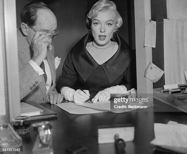 Actress Marilyn Monroe puts her signature to papers in Superior Court which put her back in circulation again. She received a divorce from Joe...