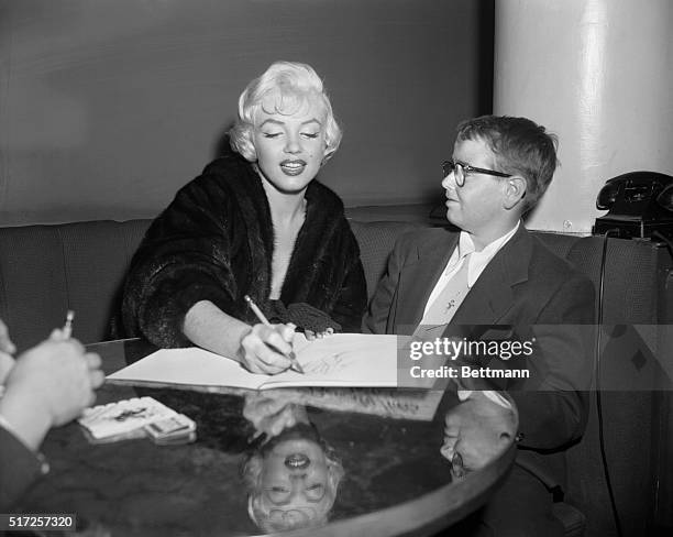 Marilyn Monroe is shown giving her autograph to Ronald Seifert, a 13 year old boy.