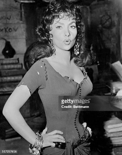 It takes a little practice, too. Paris, France: Italian actress Gina Lollobrigida, who is said to favor flexible screen kisses, limbers up her lips...