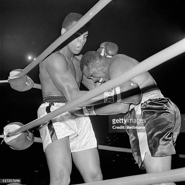 Archie Moore ducks a left thrown by Cassius Clay in a corner in the first round of their scheduled 12-round heavyweight elimination bout at the...