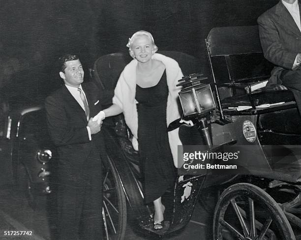 Singer Peggy Lee is assisted from a hansom cab by husband, actor Dewey Martin, on arrival at the opening of Michael P. Grace's Theater Under The...