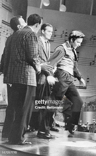 Gyrating Elvis Presley rocked 'n rolled as usual in his final appearance on Ed Sullivan's TV show tonight, but home viewers saw him only from the...