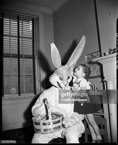 New York, NY:- Four-yar-old Rhona Rubin is sharing a treasured secret with "Peter the Rabbit" at the Easter Party for small fry, sponsored by Max...