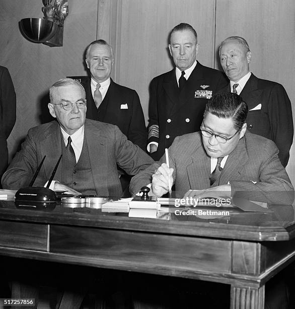 Signing mutual defense pact with Nationalist China. Washington, D.C.: Secretary of State John Foster Dulles looks on as Yeh Kung-Chao , foreign...