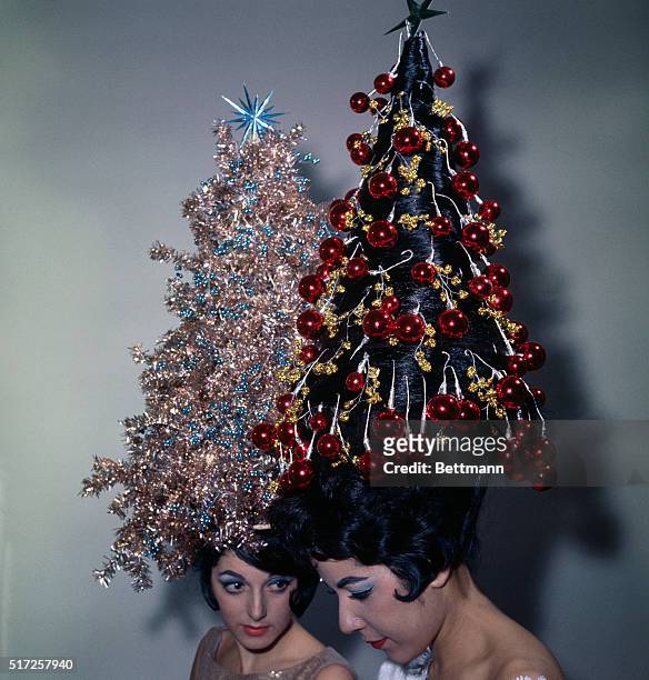 Two young women display their holiday hairdos, each with 42-inch hair decorated with tinsel and ornaments. Claudette Ackrich's hair is decorated with...