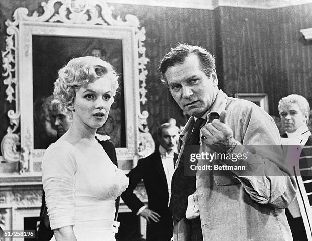 At left above is the first "still" to be released showing Marilyn Monroe at work on the set of The Sleeping Prince in which she is co starred with...