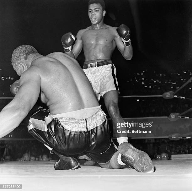 Cassius Clay towers over the fallen Archie Moore after the last knockdown in the fourth round here November 15th. Archie was called out at 1:35 of...