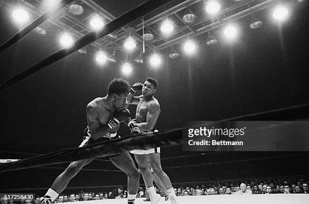 Charlie Powell, tries to defend himself as Cassius Clay starts his attack in the third round of their fight here January 24. Clay knocked out Powell...