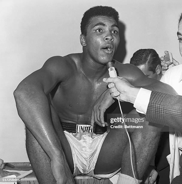 Muhammad Ali talks to journalists after defeating Archie Moore in a Heavyweight title elimination match.