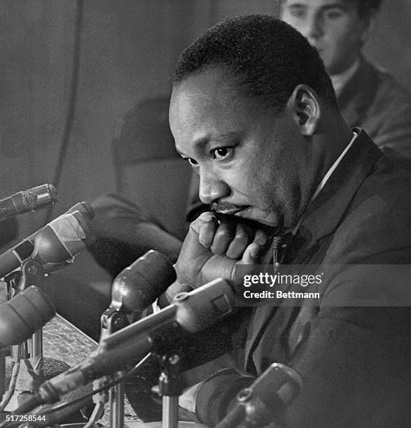 Reverend Martin Luther King peers over a battery of microphones during a press conference at Christ Church near Harvard University in this...