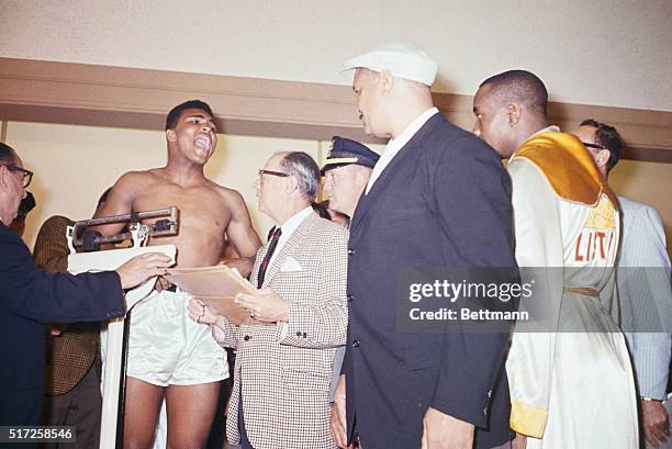 Cassius Clay yells at heavyweight champion Sonny Liston during weigh-in here for their title fight. Clay was fined $2,500 for his "conduct on the...