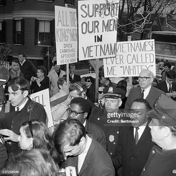 Rev. Martin Luther King Jr. Is flanked by policeman as he is picketed by group of Harvard students after leaving a house on Martin Street where he...