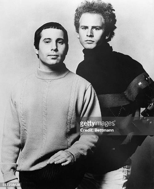 Paul Simon and Art Garfunkel, of the Simon & Garfunkel singing team, pose in a standing, waist-up, studio portrait.