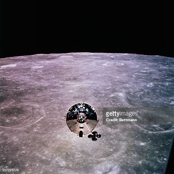Gleaming in the sun's rays, Apollo 10 Command Service Module orbits 70 miles above the Moon's surface in this view taken from the Lunar Module after...