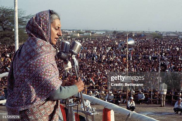 Mrs. Gandhi Campaigns. New Delhi, India: Mrs. Indira Gandhi, premier of India, with her face surrounded by floral garlands, addresses a public...