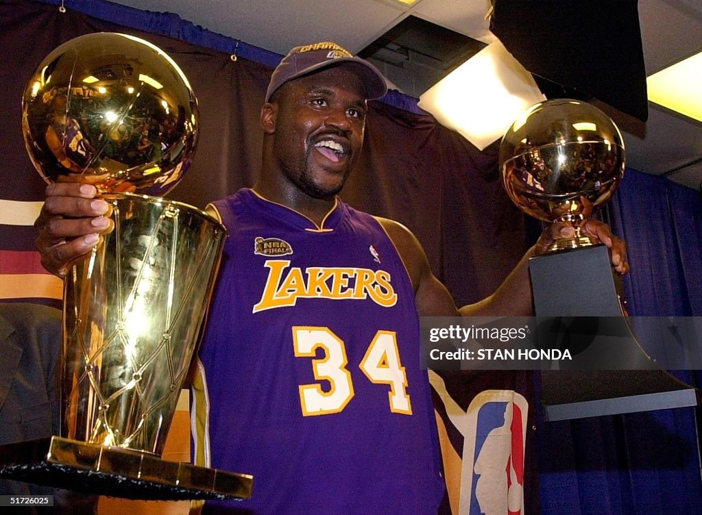 Shaquille O'Neal holds the MVP trophy (R) and the