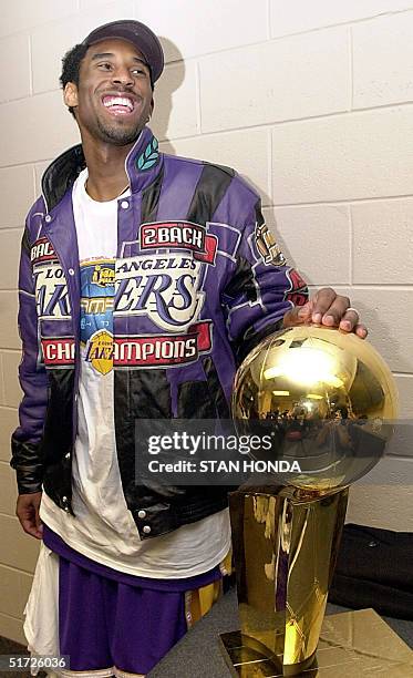 Kobe Bryant of the Los Angeles Lakers holds the championship trophy after winning game five of the NBA Finals against the Philadelphia 76ers 15 June,...
