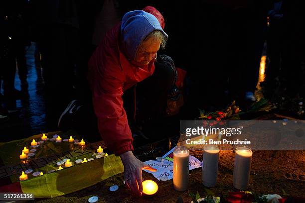 Mourner lights a candle in Trafalgar Square during a candlelit vigil in support of the victims of the recent terror attacks in Brussels on March 24,...
