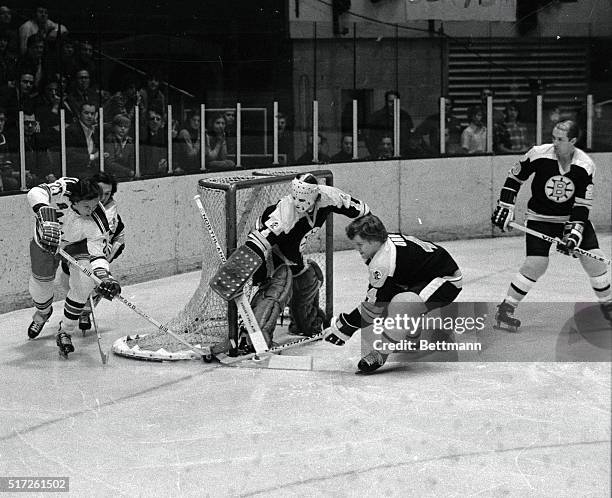 Boston Bruins' goalie Gilles Gilbert and teammates Bobby Orr and Real Lemieux prevent NY Rangers' Ted Irvine from scoring during first period of game...