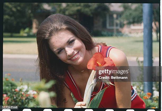 Miss America, Phyllis George, holds a flower.