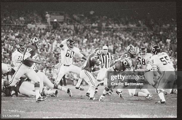 Wally Chambers, of the Bears leaps toward Redskin's Charley Harraway, , as Harraway goes through the Bear line in the 1st quarter of their game.