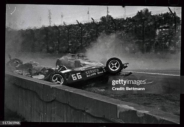 Speedway:Bobby Unser of Albuquerque, NM., skids past flaming wreckage of Mark Donohue which was hit by car driven by Mike Mosley after collision on...