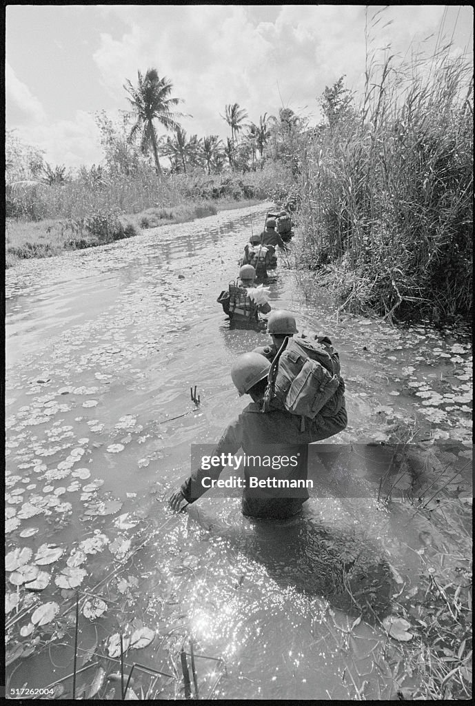 Photo: Soldati sudvietnamiti attraversano una zonna allagata nella provincia meridionale di Camau, 24 agosto 1962. (AP Photo/Horst Faas)