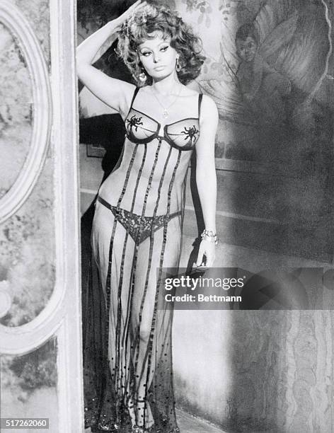 Academy Award-winning actress Sophia Loren poses in a slave girl outfit of lace bikini and harem veil in scene from her new movie, Marriage Italian...