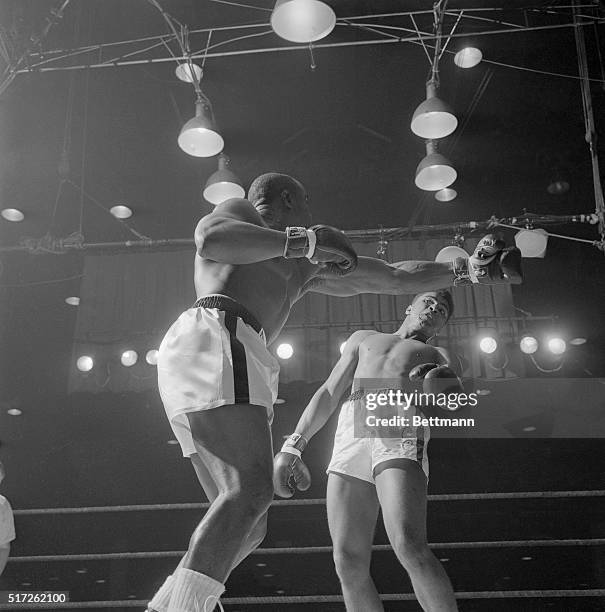 Boxer Cassius Clay backs away from Sonny Liston's punch in the first round of the heavyweight title fight. Clay later known as Muhammad Ali fought...