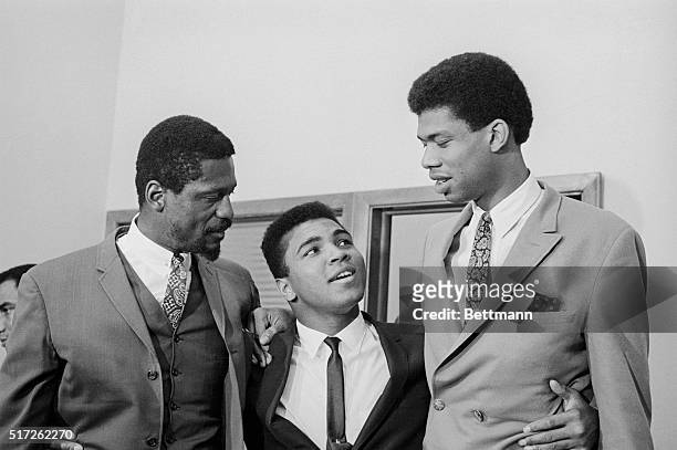 Dwarfed by Bill Russell , six-foot, 11-inch player coach of the Boston Celtics, and 7-foot, 3-inch college star Lew Alcindor, Cassius Clay strains...