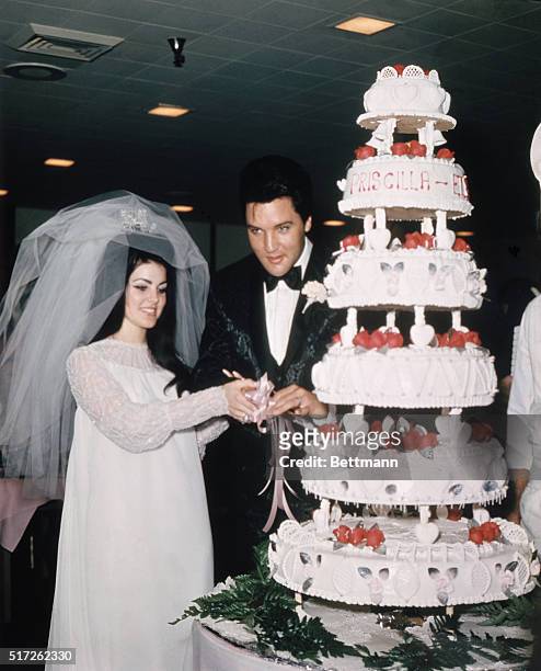 Las Vegas, Nevada, Entertainer, Elvis Presley cuts wedding cake with his bride, the former Priscilla Ann Beaulieu, May 1, 1967.
