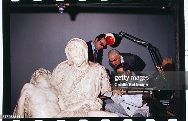 Vatican City, Italy: Art expert Nazarene Gabrielli checks damage to left arm of Michaelangelo's famed "Pieta" here. The statue was smashed by a...