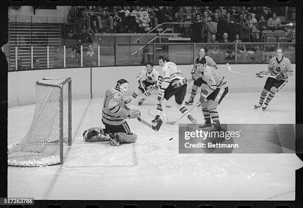 All Star Game. New York: West Division's goalie Tony Esposito watches puck as teammate Barry Gibbs heads at him during NHL East-West Division...