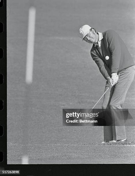 Augusta, Ga.: Tommy Aaron chips onto number two green during his sizzling 4-under par 32 over the front nine of the Augusta National to take an early...