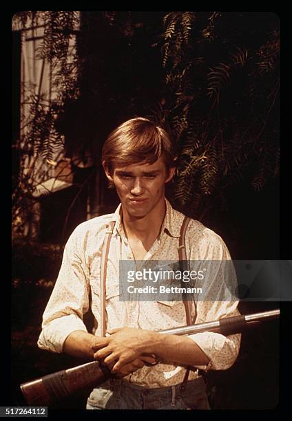 Closeup of actor Richard Thomas in scene with rifle from the television series The Waltons undated publicity handout.