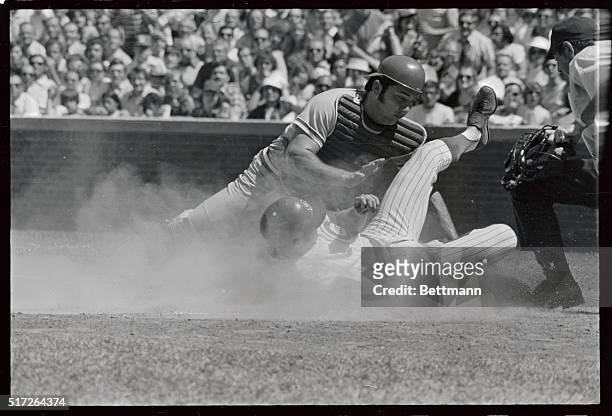 Chicago Cubs' Randy Hundley slides into the plate but is tagged out by Cincinnati Reds' catcher Johnny Bench on a squeeze play in the fourth inning...