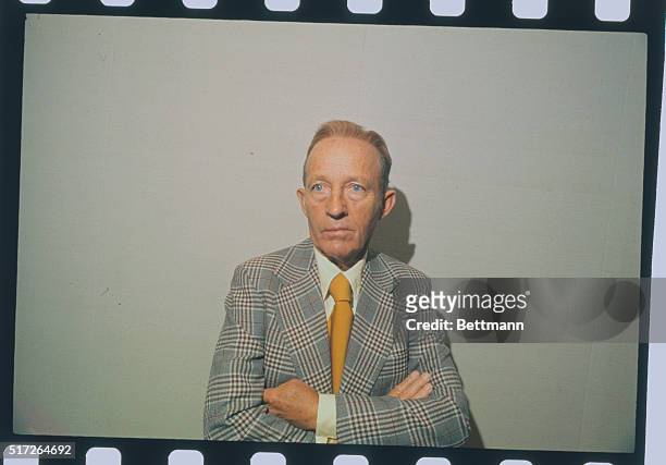 Bing Crosby, singer, is shown here with his arms crossed during a press conference.