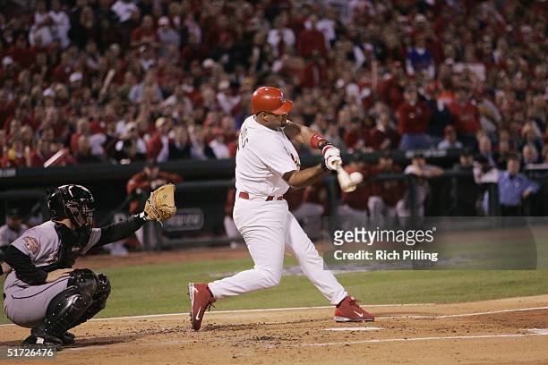 Albert Pujols of the St. Louis Cardinals hits a two run home run in the first inning during game one of the NLCS against the Houston Astros at Busch...