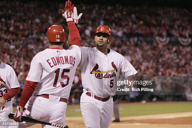 Albert Pujols is congratulated by Jim Edmonds of the St. Louis Cardinals after hitting a home run during the first inning of game one of the NLCS...