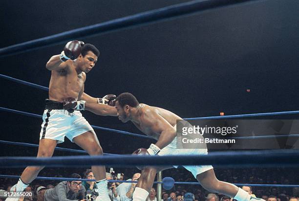 Joe Frazier crouch's and lands a right to the stomach of Muhammad Ali in bout here January 28. Ali won unanimous decision in the 12-rounder. Both...