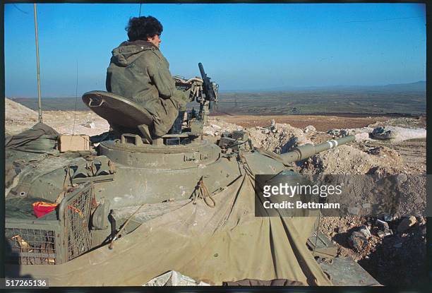 Tel Aviv, Israel. Soldier sitting atop tank on Golan Heights views Plains below and road leading to Damascus. Israel says Syrian gunners fired...