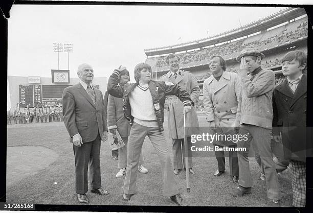 Lifting his cane off the ground, 12 year old Teddy Kennedy rears back to throw out the first ball at Shea Stadium for the opening game of the season...