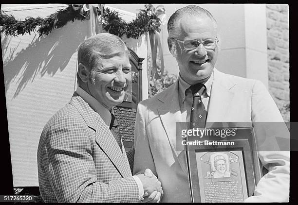 New York Yankee superstar Mickey Mantle shares a laugh with Baseball Commissioner Bowie Khun during ceremonies inducting Mantle and five other...