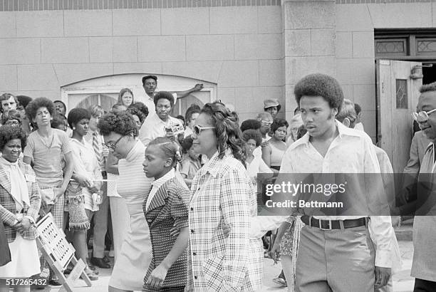 Coretta King, wife of slain Civil rights leader, Dr. Martin Luther King, Jr., is escorted from Ebenezer Baptist Church, after paying her respects to...