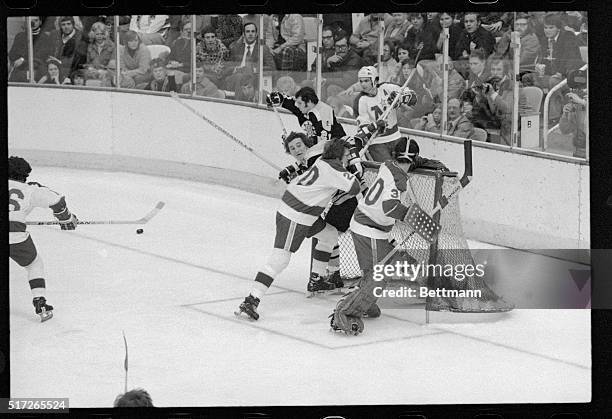 Bloomington, Minnesota: North Stars' defenseman Tom Reid pins Bruin's Andre Savard to the front of the goals preventing him from reaching the puck...