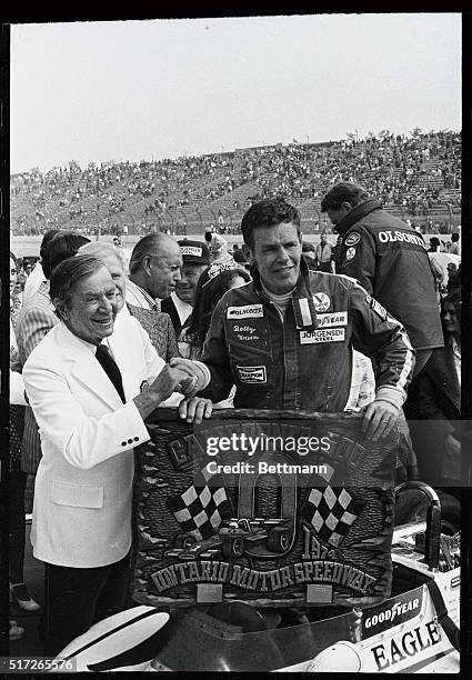 Bobby Unser holds winning emblem after winning the 5th Annual California 500 at the Ontario Motor Speedway. His mother and girlfriend were on hand...