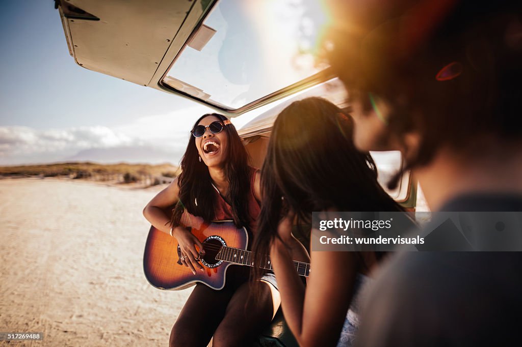 Hipster Multi-Ethnic Group Play Guitar at Beach