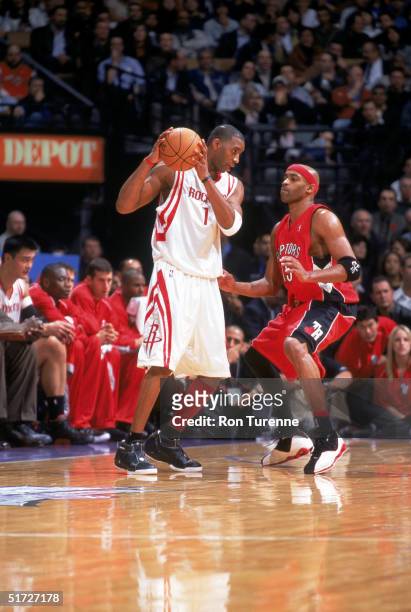 Tracy McGrady of the Houston Rockets is defended by Vince Carter of the Toronto Raptors during the game at the Air Canada Centre on November 3, 2004...